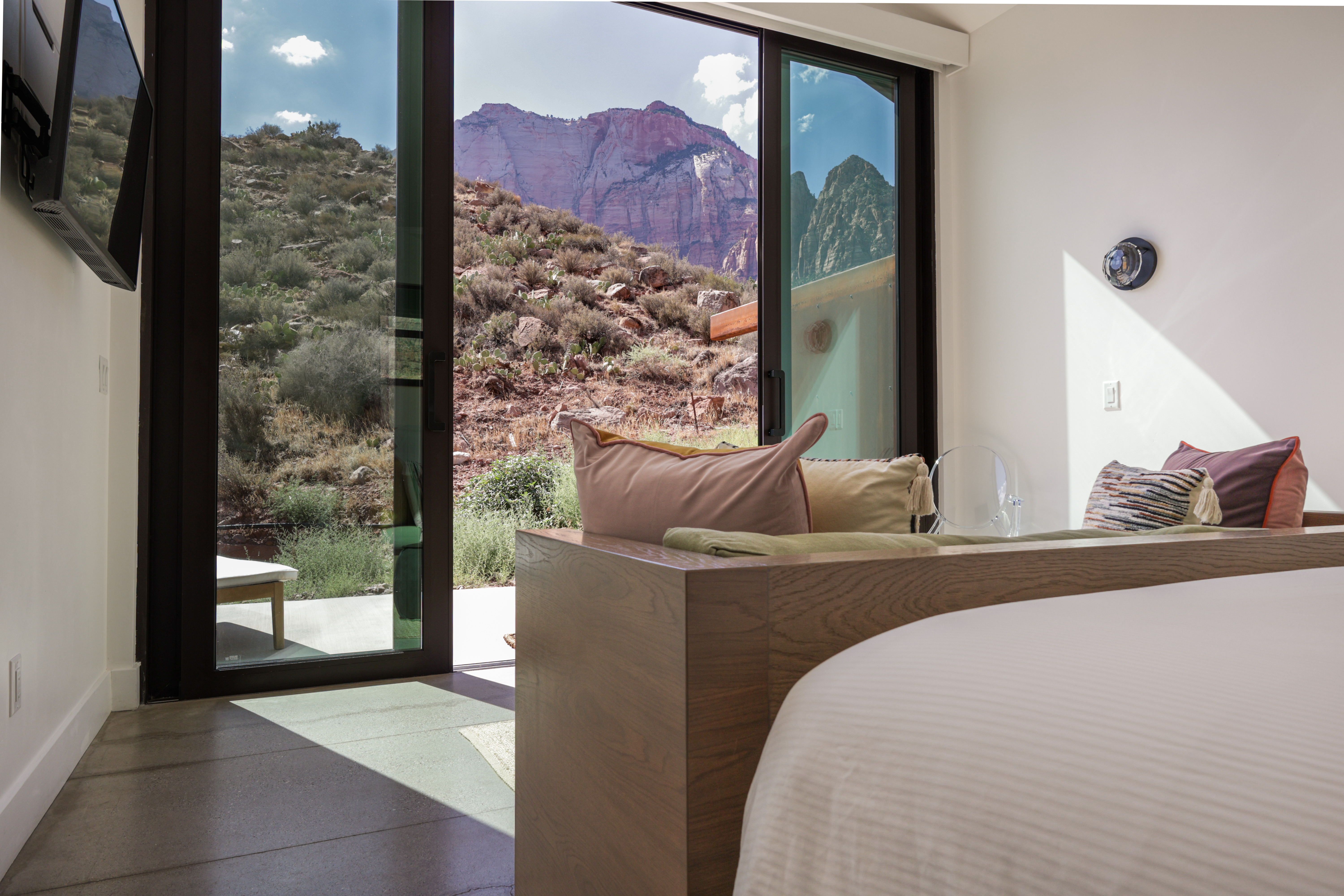 Guest room opening to a red-rock landscape
